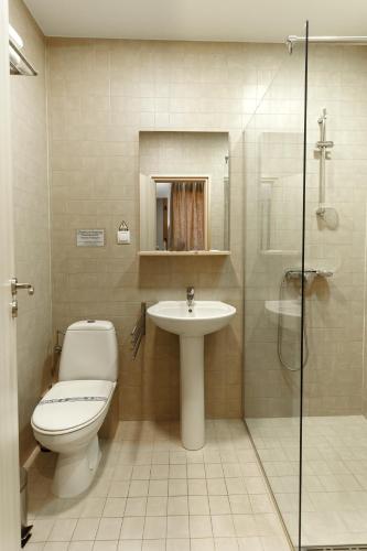 a bathroom with a toilet and a sink and a shower at Pensiunea Kristall Tecuci in Tecuci