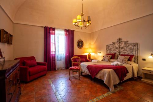 a bedroom with a bed and a red chair at Agriturismo Il Convento in Massa Lubrense