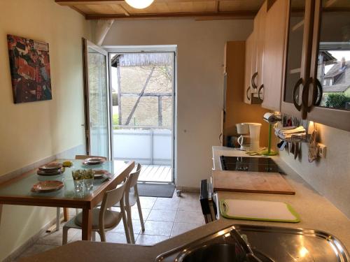 a small kitchen with a table and a counter top at Apartment in Gelb, mit Balkon, Kamin, 50 Schritte zu Radweg, ideal for Long Stay, 4 Singles in Single Rooms in Mainstockheim