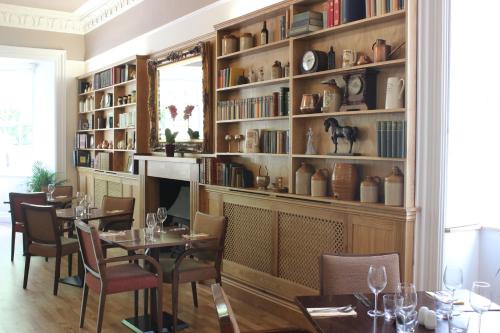 a dining room with a table and chairs and bookshelves at The Frocester in Stonehouse