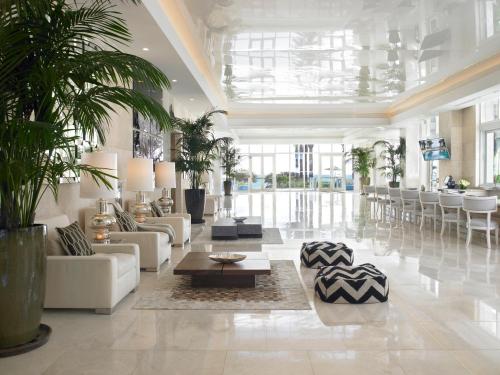 a lobby with couches and a table and chairs at Grand Beach Hotel Surfside in Miami Beach