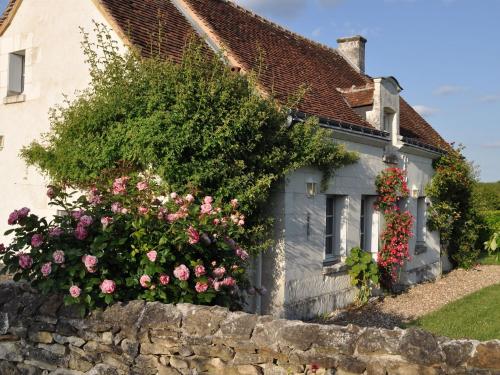 an old house with flowers on a stone wall at Snug Holiday Home in Chambourg Sur Indre with Pool in Chambourg-sur-Indre