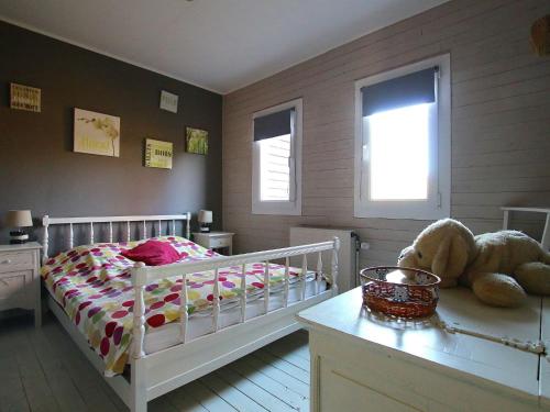 a childs bedroom with a white bed and a window at Peaceful Chalet in Transinne with Patio in Libin