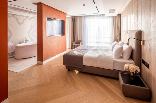 a bedroom with a bed and a bathroom with a tub at Loft7 in Lviv