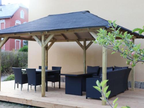 un pabellón de madera con una mesa y sillas en una terraza en Villa with home cinema sauna en Treuen