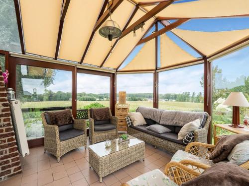 a screened in porch with couches and chairs at Stunning Holiday Home in Oombergen with Terrace and Garden in Zottegem