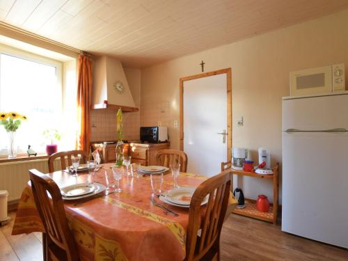 cocina con mesa y nevera blanca en Cozy Holiday Home near the Forest in Bovigny, en Gouvy