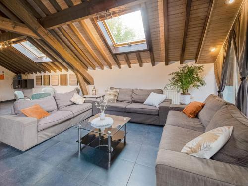 Sala de estar con 2 sofás y mesa en Charming cottage with jacuzzi and sauna High Fens, en Waimes