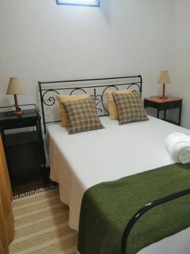 - une chambre avec un grand lit blanc et des oreillers dans l'établissement Casas da Saibreira - nº10, à Elvas