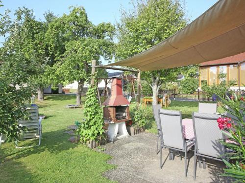 un patio con sillas y una parrilla en Apartment with terrace in the garden, en Pracht