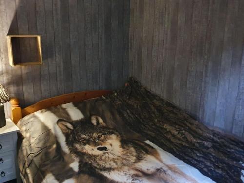 ディルセン・ストッケムにあるPeacefully chalet in Lanklaar with gardenのベッドの上に寝た狼
