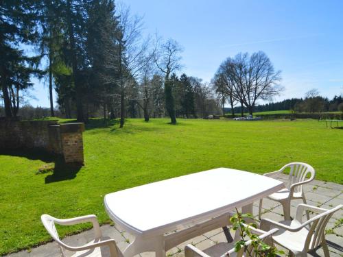 una mesa de picnic blanca y sillas en un parque en Modern Cottage in Barvaux Condroz Amidst Meadows, en Barvaux-Condroz