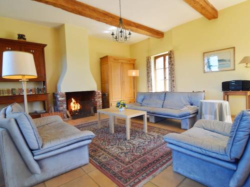 sala de estar con sofás azules y chimenea en Modern Cottage in Barvaux Condroz Amidst Meadows, en Barvaux-Condroz