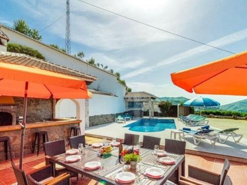 a villa with a swimming pool and a table and chairs at Belvilla by OYO Villa Javier in Sayalonga