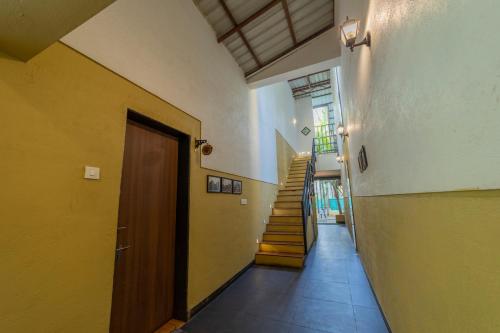 a hallway with a door and stairs in a building at Coconut Beach Farm in Alibaug