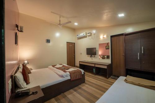 a bedroom with a bed and a bathroom with a sink at Coconut Beach Farm in Alibaug