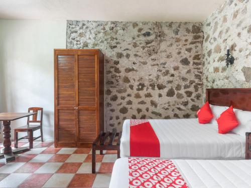 a hotel room with two beds and a table at Rancho Hotel El Carmen in Tlapacoyan