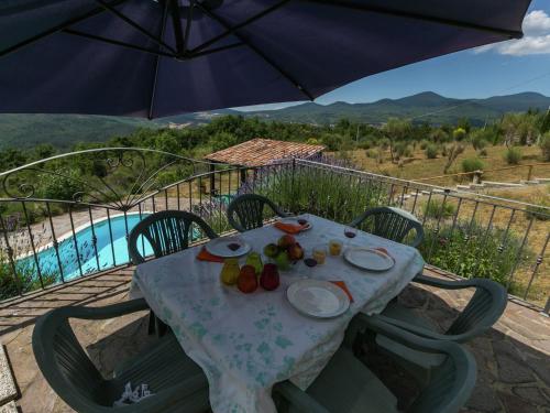 uma mesa com pratos de fruta e um guarda-chuva em Belvilla by OYO Monte Amiata em Santa Fiora