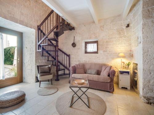 アルベロベッロにあるCozy Cottage in Alberobello with Private Gardenのリビングルーム(ソファ付)、螺旋階段