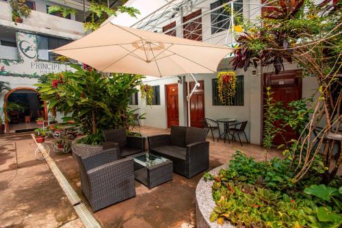 a patio with an umbrella and chairs and a table at Hotel Principe I in Puerto Maldonado