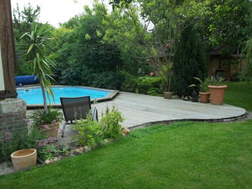 une arrière-cour avec une terrasse en bois et une piscine dans l'établissement Chambre d'Hôtes des P'tits Bonheurs, à Dosches
