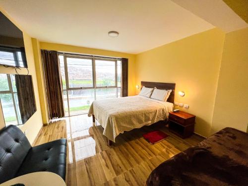 1 dormitorio con cama, sofá y ventana en HOTEL DORADO AREQUIPA, en La Apacheta