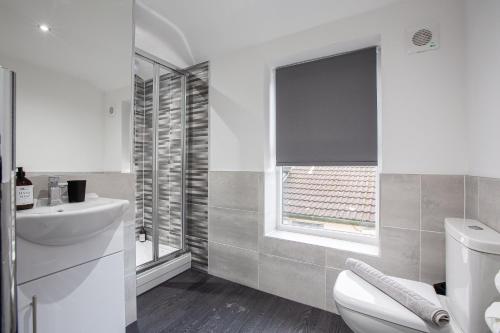 baño con aseo y lavabo y ventana en Charles Alexander Short Stay - The Gateway en Blackpool