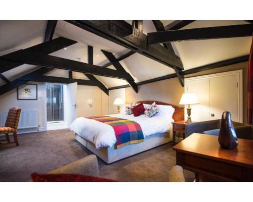 a bedroom with a king sized bed and a desk at Seven Stars in Dartmouth