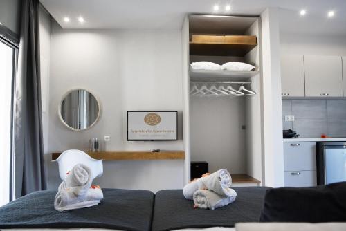 a bedroom with towels on a bed and a kitchen at Spyridoula Resort in Corfu in Gouvia