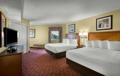 a hotel room with two beds and a flat screen tv at Bay View Resort Myrtle Beach in Myrtle Beach