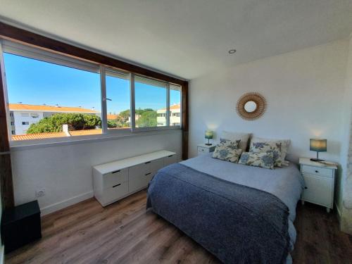 a bedroom with a bed and a large window at White House in Parede