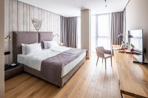 a bedroom with a bed and a desk and a chair at Loft7 in Lviv