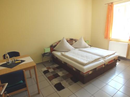 a bedroom with a bed and a table and a window at Rezas Restaurant Gästehaus in Oberbillig