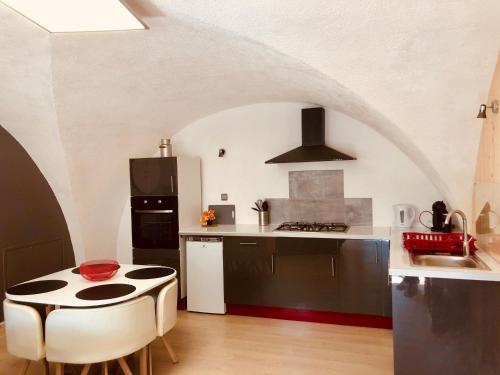 uma cozinha com uma mesa e um fogão forno superior em Gîtes de Chauvet em Gap