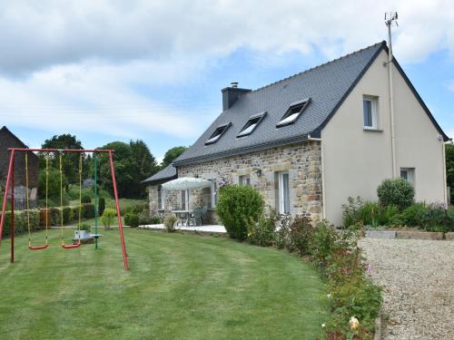 a house with a yard with a swing at Tasteful holiday home in Plouvara with garden in Saint-Donan