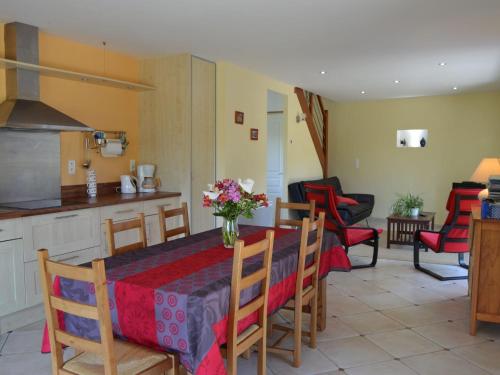 a kitchen and living room with a table and chairs at Cosy chalet with private garden in Normandy in Isigny-le-Buat