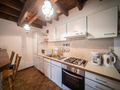 a kitchen with white cabinets and a stove top oven at Charming flat with barbecue in Dombasle-devant-Darney