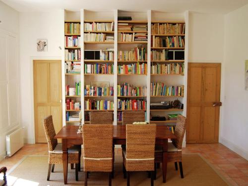 a dining room with a table and chairs and bookshelves at Beautiful appartment with pool in Provence in Valréas