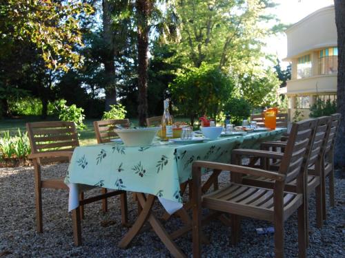una mesa con sillas y un mantel. en G te with friends room in stately villa with pool and parkgarden, en Valréas