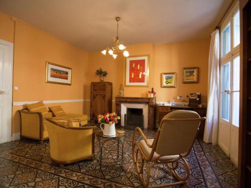 uma sala de estar com cadeiras e uma lareira em Old wine storehouse with terrace and garden em Puimisson