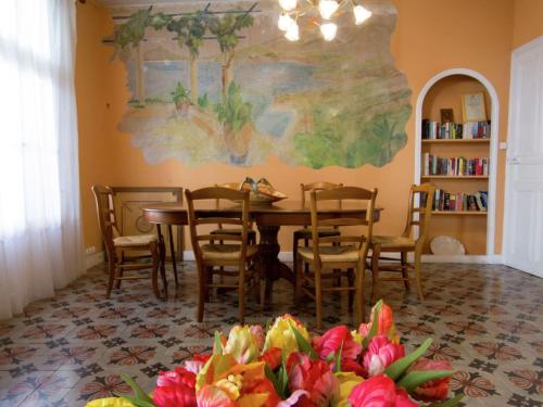 a dining room with a table and chairs and a painting at Old wine storehouse with terrace and garden in Puimisson