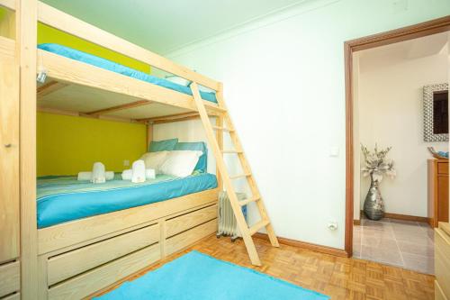 a bunk bed with a ladder in a room at Tamargueira Beach Apartment in Buarcos