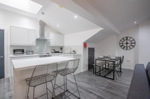 a kitchen with a counter and chairs in a room at Charles Alexander Short Stay - The Gateway in Blackpool