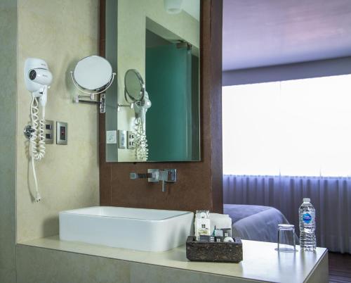 ein Badezimmer mit einem weißen Waschbecken und einem Spiegel in der Unterkunft Hotel Brasilia in Mexiko-Stadt