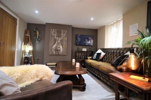 a living room with a leather couch and a table at Stylish Loft Apartment by Property Promise in Cardiff