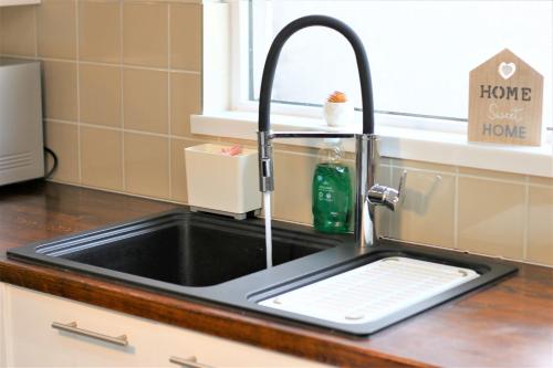 a sink in a kitchen with a window at Stylish Loft Apartment by Property Promise in Cardiff