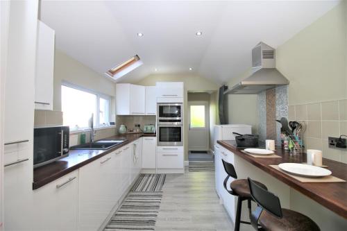 a kitchen with white cabinets and a counter top at Stylish Loft Apartment by Property Promise in Cardiff
