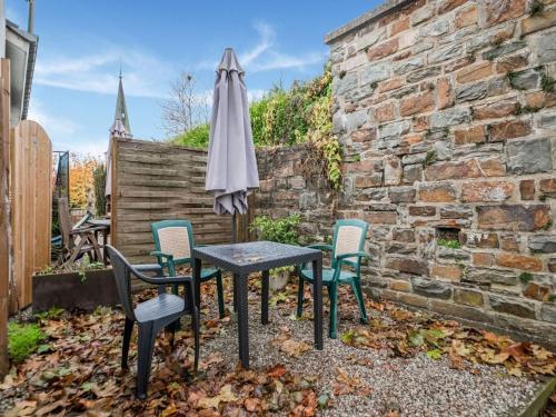 un tavolo con sedie e un ombrellone in giardino di Cosy Holiday Home in Cherain near Forest a Cherain
