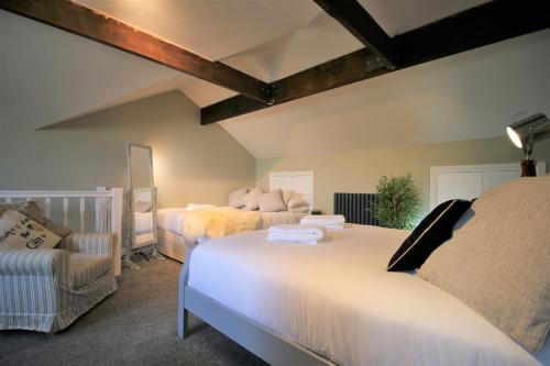 a bedroom with two beds and a chair at Stylish Loft Apartment by Property Promise in Cardiff
