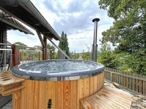 un bain à remous installé au-dessus d'une terrasse en bois dans l'établissement Wooden holiday home with sauna, à Teunz